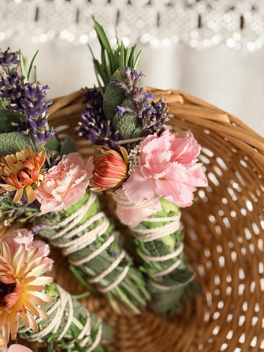 Decorative wreath with flowers and greenery on a woven surface
